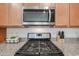 Close up of the kitchen stove and microwave, highlighting the granite countertop and modern appliances at 4609 S 122Nd S Dr, Avondale, AZ 85323