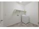 Bright laundry room with a white washer, tiled floor, and ample shelving space at 4609 S 122Nd S Dr, Avondale, AZ 85323