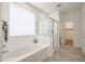 A serene main bathroom featuring a separate shower, tub, and a large window for natural light at 4609 S 122Nd S Dr, Avondale, AZ 85323