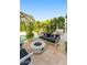 A backyard patio features a fire pit, built-in grill, lounge chairs, and mature landscaping creating a perfect outdoor retreat at 7242 E Joshua Tree Ln, Scottsdale, AZ 85250