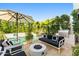 A backyard patio features a fire pit, built-in grill, lounge chairs, and mature landscaping creating a perfect outdoor retreat at 7242 E Joshua Tree Ln, Scottsdale, AZ 85250