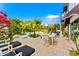 A backyard patio features a dining table, lounge chairs, and mature landscaping creating a perfect outdoor retreat at 7242 E Joshua Tree Ln, Scottsdale, AZ 85250