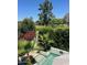 Lush backyard featuring vibrant greenery, a clear pool, and scenic views of the adjacent trees and golf course at 7242 E Joshua Tree Ln, Scottsdale, AZ 85250
