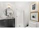 Modern bathroom features a black vanity with a round mirror and a walk-in shower with white tile at 7242 E Joshua Tree Ln, Scottsdale, AZ 85250
