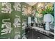 Chic powder room with tiger wallpaper, black marble vanity, and elegant floral arrangement at 7242 E Joshua Tree Ln, Scottsdale, AZ 85250