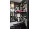 Chic bathroom with tiger-striped wallpaper, marble countertop, and decorative mirror and lighting at 7242 E Joshua Tree Ln, Scottsdale, AZ 85250