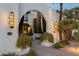Inviting courtyard with neutral stone, potted succulents, and decorative wall sconces at 7242 E Joshua Tree Ln, Scottsdale, AZ 85250