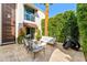 Outdoor patio features comfortable seating, modern art, and lush, mature landscaping at 7242 E Joshua Tree Ln, Scottsdale, AZ 85250