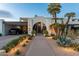 Beautiful home featuring desert landscaping, an arched entryway, and a covered carport at 7242 E Joshua Tree Ln, Scottsdale, AZ 85250