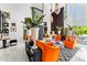 Bright living room with vibrant orange sofas, high ceilings, and stylish decor at 7242 E Joshua Tree Ln, Scottsdale, AZ 85250