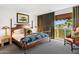 Comfortable bedroom with a wooden four-poster bed, cozy linens, stylish furniture, and a view of the outdoors at 7242 E Joshua Tree Ln, Scottsdale, AZ 85250