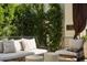Outdoor patio features modern furniture, decorative pillows, and lush, green privacy landscaping at 7242 E Joshua Tree Ln, Scottsdale, AZ 85250