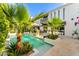 A beautiful pool is surrounded by mature plants and travertine deck creating a private backyard oasis at 7242 E Joshua Tree Ln, Scottsdale, AZ 85250