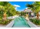 A long, rectangular pool features fountains and lush landscaping providing a serene and private backyard retreat at 7242 E Joshua Tree Ln, Scottsdale, AZ 85250