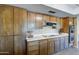 Traditional-style kitchen features wood cabinets, white countertops, stainless steel appliances, and fruit basket detail at 7616 W Wagoner Rd, Glendale, AZ 85308