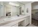 Bathroom vanity with dual sinks, a large mirror, white cabinets, and views of the bedroom and closet at 7841 N 18Th St, Phoenix, AZ 85020