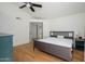 Spacious bedroom with a hardwood floor, ceiling fan, light gray furniture, and access to another room at 7841 N 18Th St, Phoenix, AZ 85020