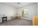 Well-lit bedroom featuring a ceiling fan, carpet flooring, and a serene backyard view from the window at 7841 N 18Th St, Phoenix, AZ 85020