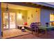 Cozy covered patio with comfortable seating, an outdoor dining area, and a view into the well-lit interior at 7841 N 18Th St, Phoenix, AZ 85020