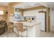 Bright kitchen featuring white appliances, tiled countertops, and a cozy breakfast bar with seating at 7841 N 18Th St, Phoenix, AZ 85020