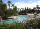 Relaxing pool area surrounded by lush palm trees, umbrellas, lounge chairs, and tropical foliage at 7841 N 18Th St, Phoenix, AZ 85020