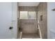 Accessible shower with neutral tile, a built-in bench, and a window for natural light at 7841 N 18Th St, Phoenix, AZ 85020