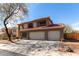 Two-story home with an attached three-car garage, desert landscaping, and a decorative stone pathway to the front door at 100 N 221St Ave, Buckeye, AZ 85326