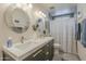 Modern bathroom featuring double sinks, stylish mirrors, and a shower with a decorative curtain at 1027 W Julie Dr, Tempe, AZ 85283