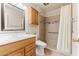 Tiled bathroom with safety bars, a tiled shower, and a comfortable vanity, offering accessibility and convenience at 10521 W Roundelay Cir, Sun City, AZ 85351