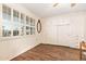 Bright bedroom featuring beautiful wood-look flooring, built-in wardrobe, storage cabinets, and shuttered windows at 10521 W Roundelay Cir, Sun City, AZ 85351