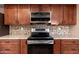 Close up of kitchen with stainless steel appliances, granite countertops, and tile backsplash at 10521 W Roundelay Cir, Sun City, AZ 85351