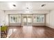 Inviting living room with hardwood floors, a ceiling fan, and access to the patio through sliding doors at 10521 W Roundelay Cir, Sun City, AZ 85351