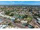 Sweeping aerial of a serene community with verdant green spaces, tennis courts, and breathtaking mountain views at 10834 N 45Th St, Phoenix, AZ 85028