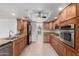 Fully equipped kitchen featuring wood cabinets, tile floors, granite countertops, and stainless appliances at 10834 N 45Th St, Phoenix, AZ 85028