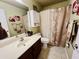 Cozy bathroom with tiled floors, white vanity, and shower with curtain at 1203 W Mesquite Tree Ln, San Tan Valley, AZ 85143