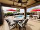 Covered patio overlooking the pool, outdoor dining and seating area, and desert landscaping at 1203 W Mesquite Tree Ln, San Tan Valley, AZ 85143