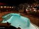 Swimming pool with desert landscaping in a beautiful yard illuminated at night for fun swims at 1203 W Mesquite Tree Ln, San Tan Valley, AZ 85143