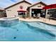 Backyard pool and spa area with patio furniture and red umbrellas at 1203 W Mesquite Tree Ln, San Tan Valley, AZ 85143