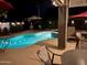 Gorgeous night view of the pool, patio, seating, and desert landscaping, complete with lighting at 1203 W Mesquite Tree Ln, San Tan Valley, AZ 85143