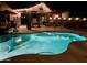 Inviting backyard pool with outdoor kitchen and patio area, perfect for evening entertaining at 1203 W Mesquite Tree Ln, San Tan Valley, AZ 85143