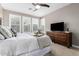 Serene bedroom with a king-size bed, neutral tones, a ceiling fan, and a dresser with a television at 13225 W Skinner Dr, Peoria, AZ 85383