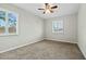 Bright bedroom with neutral walls, plush carpet, ceiling fan, and shuttered windows at 15031 N 37Th Ave, Phoenix, AZ 85053