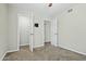 Bedroom with neutral walls, plush carpet, ceiling fan, and two open doorways at 15031 N 37Th Ave, Phoenix, AZ 85053