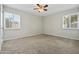 A bedroom with carpet and a ceiling fan and two windows at 15031 N 37Th Ave, Phoenix, AZ 85053