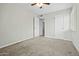 A carpeted bedroom with a ceiling fan and two white doors at 15031 N 37Th Ave, Phoenix, AZ 85053