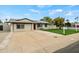Single-story home with a concrete driveway, green lawn, mature trees, and a block wall at 15031 N 37Th Ave, Phoenix, AZ 85053