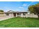 Single-story home with solar panels, dark trim, a well-maintained lawn and a block wall at 15031 N 37Th Ave, Phoenix, AZ 85053