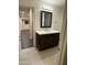 Beautiful bathroom featuring dark wood vanity with bright counters, a modern mirror, and neutral tile flooring at 1533 W 7Th St, Tempe, AZ 85281