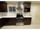 Stylish kitchen featuring stainless steel appliances, dark wood cabinetry, and bright countertops at 1533 W 7Th St, Tempe, AZ 85281
