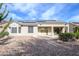 The backyard includes desert landscaping, solar panels, and a covered patio with fan at 15655 W Bethesda Ct, Surprise, AZ 85374